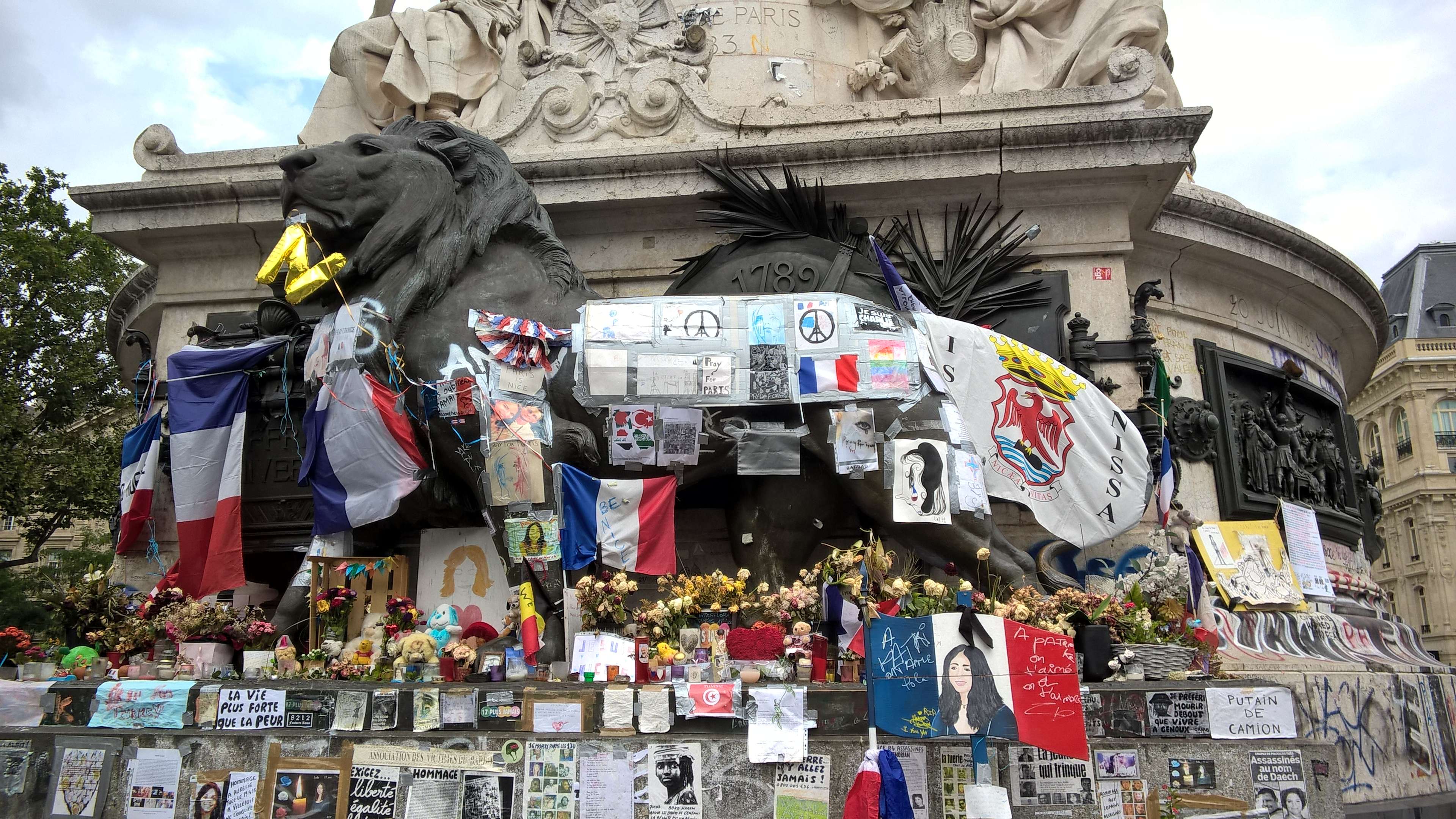 /2020/08/Le_Monument_à_la_République_recouvert_d'hommages_à_l'attentat_de_Nice_du_14_juillet_2016